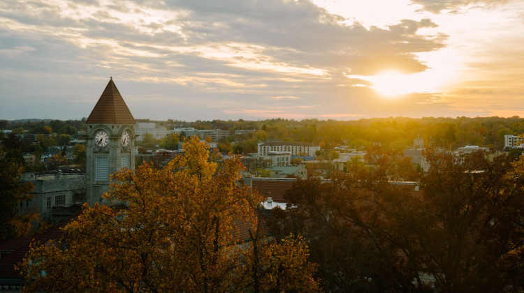 The sun shines over trees and buildings.Indiana has pushed to make college easier to enroll in and more affordable in recent years. But across its public higher education system, students of color and those from low-income families still struggle with completing college. - Sanjin Wang / Getty Images