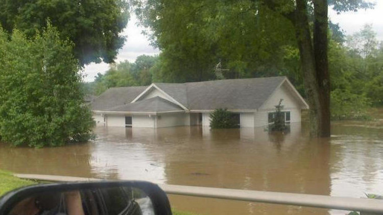 A home is half underwater from a flood in Johnson County. Prince's Lake dam breached during it, making the problem worse. - Wikimedia Commons