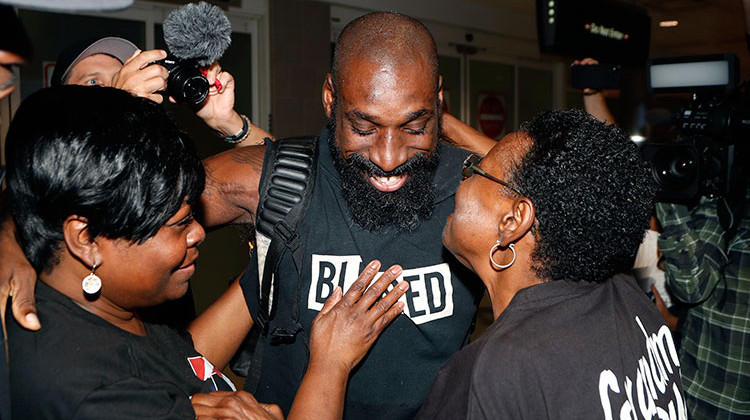 Wendell Brown hugs relatives after his arrival at the Detroit Metropolitan Airport, Wednesday, Sept. 25, 2019, in Romulus, Mich. Brown returned from China where he was imprisoned for his involvement in a bar fight. Brown, a native of Detroit had been teaching English and American football in southwest China when he was arrested in September 2016 and charged with intentional assault. - AP Photo/Carlos Osorio