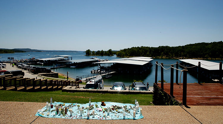 FILE - In this July 21, 2018 file photo, a small memorial for the victims of Thursday's duck boat accident overlooks Table Rock Lake in Branson, Mo. The company that owns the Ride the Ducks operation in Branson is asking a judge to dismiss some of the lawsuits filed after one of its boats sank on the Missouri lake, killing 17 people. - AP Photo/Charlie Riedel, File