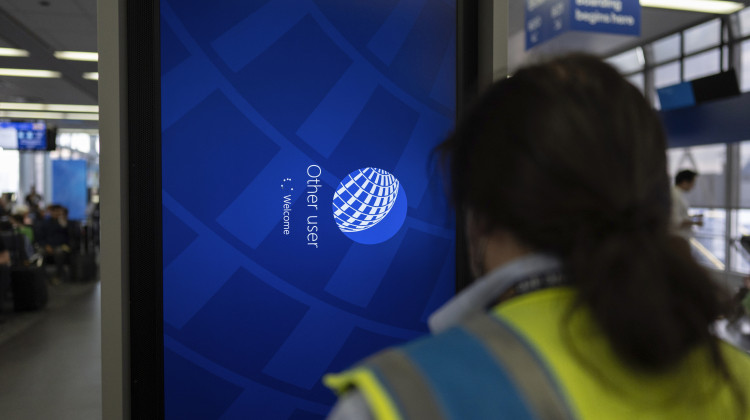An IT field services technician works on software on an information display near United Airlines gates at Chicago O'Hare International Airport, in Chicago, Friday, July 19, 2024, after software issues delayed and canceled flights globally. (AP Photo/Carolyn Kaster)