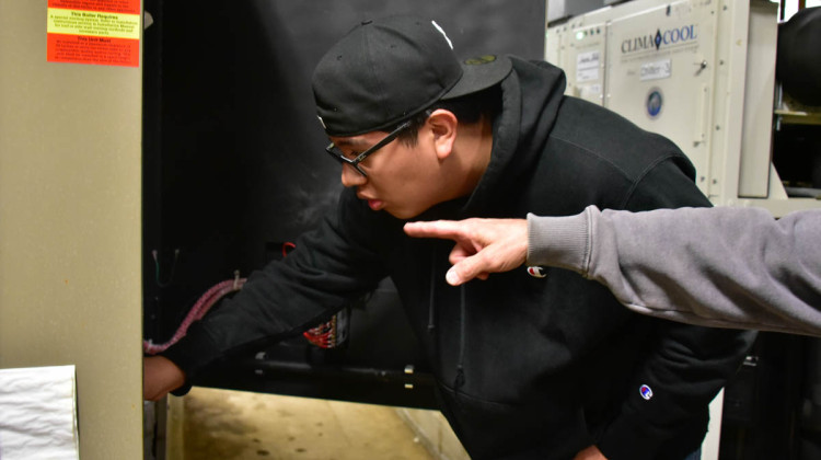 Ramiro Delgado, an apprentice through the the Modern Apprenticeship Program in 2021, looks at a boiler in a school building. State and local organizations have emphasized apprenticeship programs and work-based learning in recent years. - FILE PHOTO: Justin Hicks / IPB News