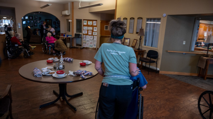 A worker at the Prairie View Nursing Home in Sanborn, Iowa, wheels a resident after lunch. The nursing home has faced chronic staffing shortages that were made worse by the COVID-19 pandemic. - Natalie Krebs / Side Effects Public Media