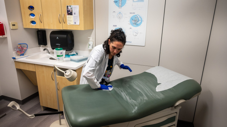 Shira Klane, a nurse practitioner who works in Planned Parenthood clinic across Minnesota, cleans an exam room in the Mankato clinic where she is working for the day to fill some vacancies. - Natalie Krebs / Side Effects Public Media