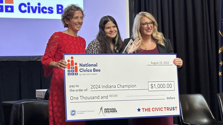 Ellie Fost, winner of  Indiana’s first Civics Bee, stands between Indiana Chamber president and CEO Vanessa Green Sinders and Secretary of Education Katie Jenner, l to r,  on Friday, Aug. 26, 2024 at the Statehouse. - Rachel Fradette / WFYI