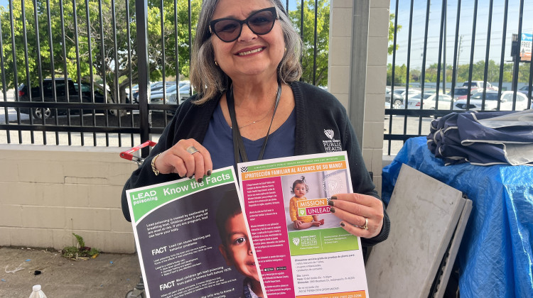 Maryori Duarte-Sheffield, a health educator for the Marion County Public Health Department holds up lead exposure resources at an immigration fair.  - Violet Comber-Wilen / IPB News