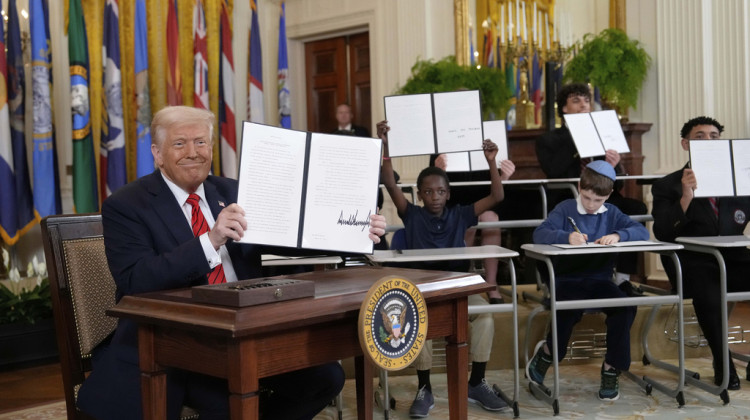 President Donald Trump, left, holds up a signed executive order as young people hold up copies of the executive order they signed at an education event in the East Room of the White House in Washington, Thursday, March 20, 2025.  - Ben Curtis/AP Photo